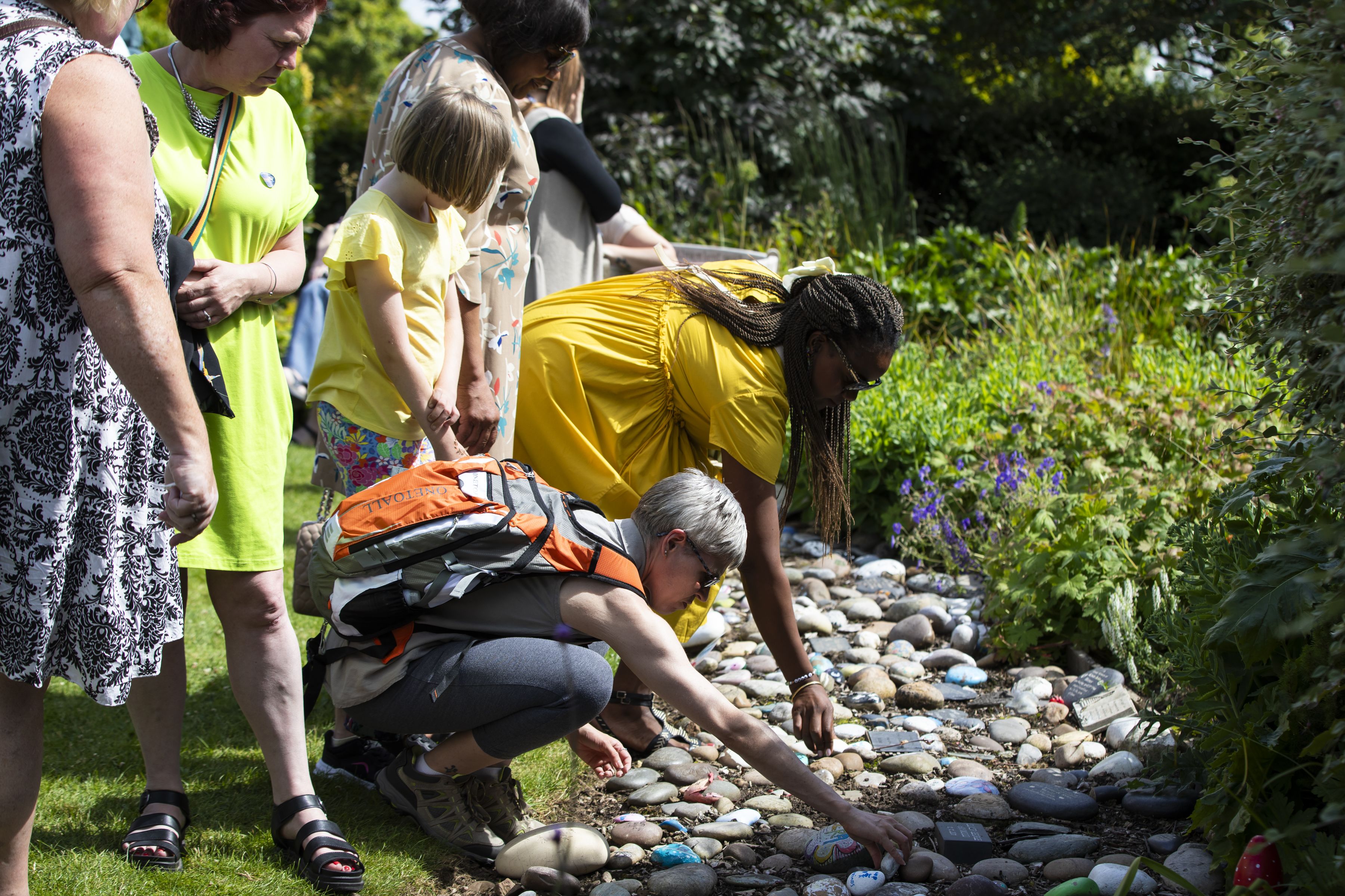 Families lay stones with their baby’s names on them in the Sands Garden at the National Memorial Arboretum. 