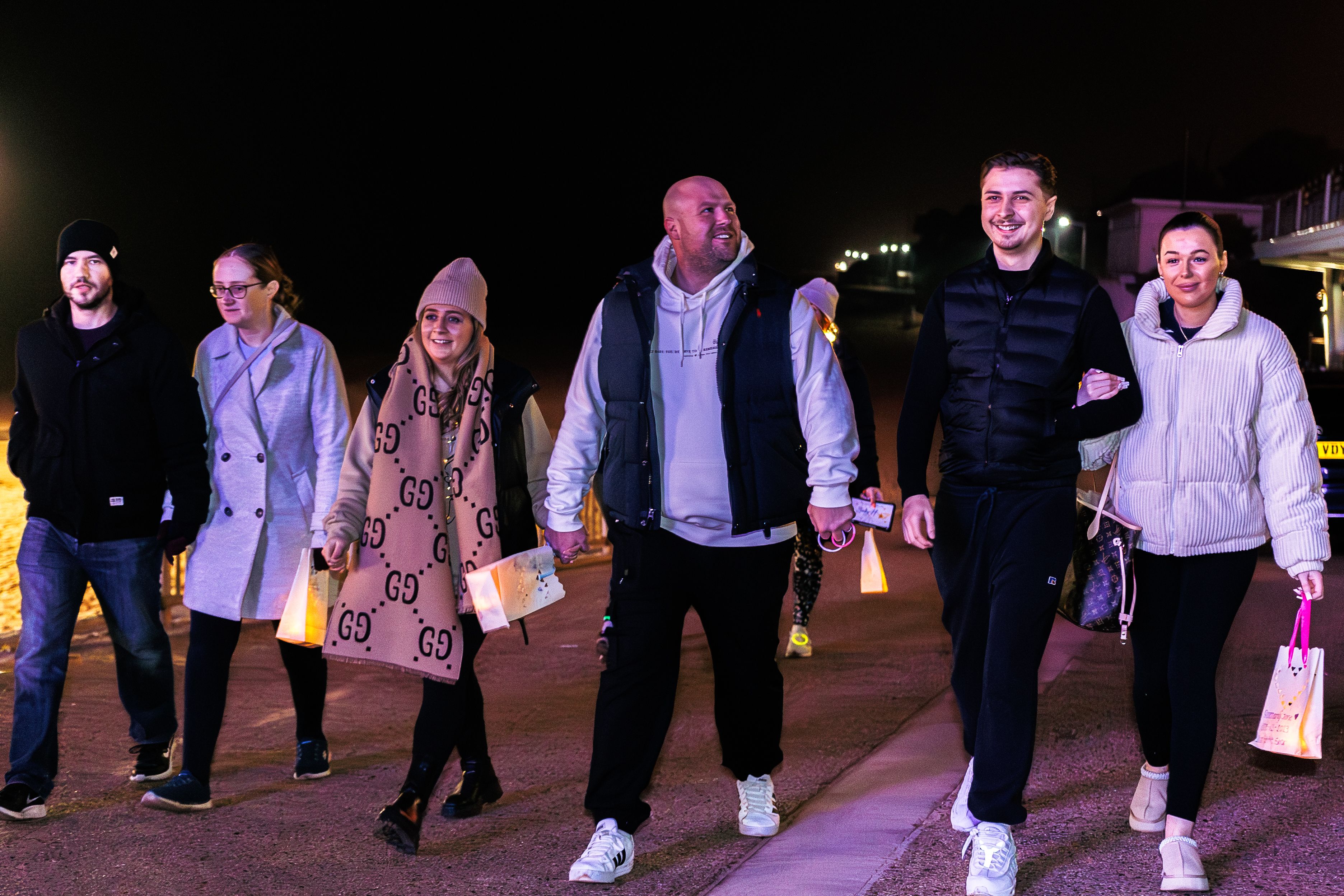 A group of people walking in the dark with their lanterns lit in memory of their much-loved babies as part of a Sands Starlight Walk event. 