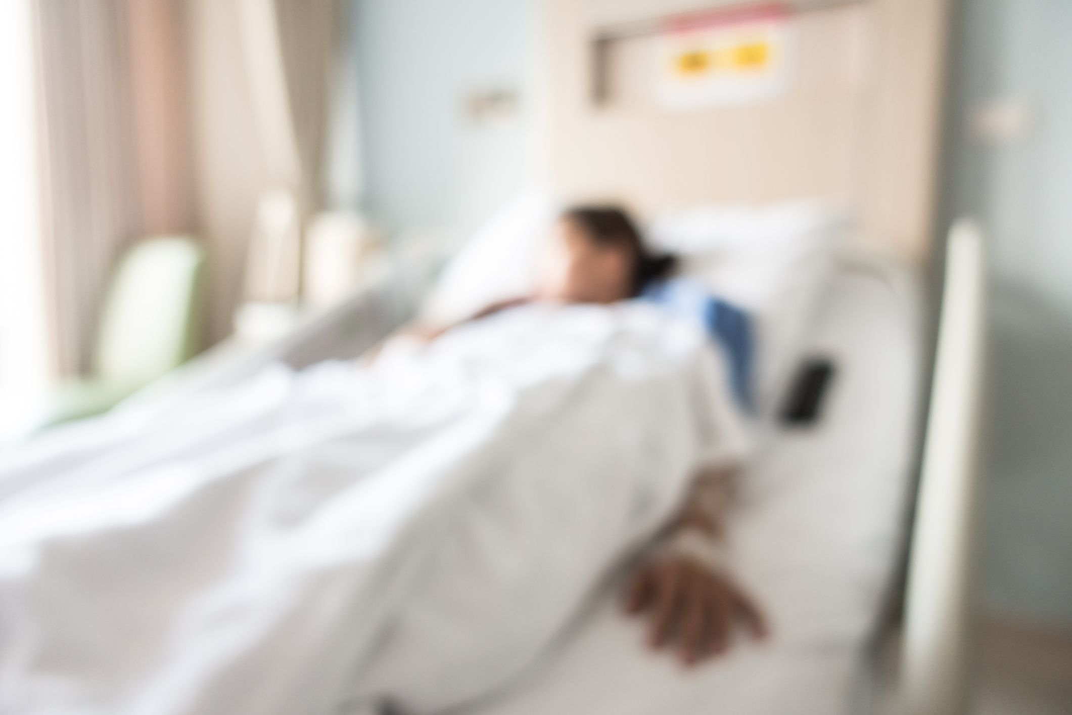 Blurry photo of a mother laying in a hospital bed. 