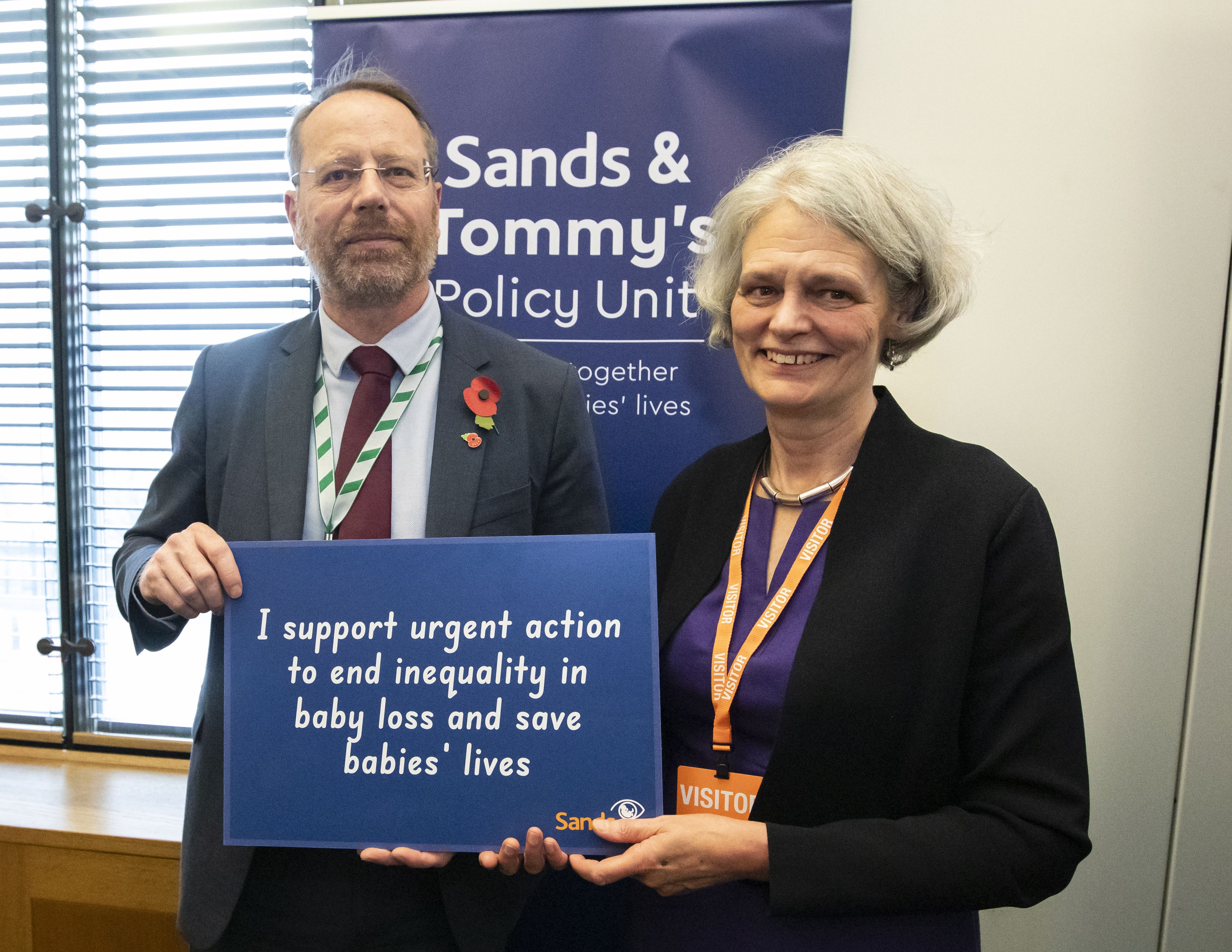 Clea Harmer, Sands Chief Executive, is stood next to Andy MacNae MP, a Labour MP and the chair of the All-Party Parliamentary Group on Baby Loss. He is holding a sign which reads ‘I support urgent action to end inequality in baby loss and save babies’ lives.’ 