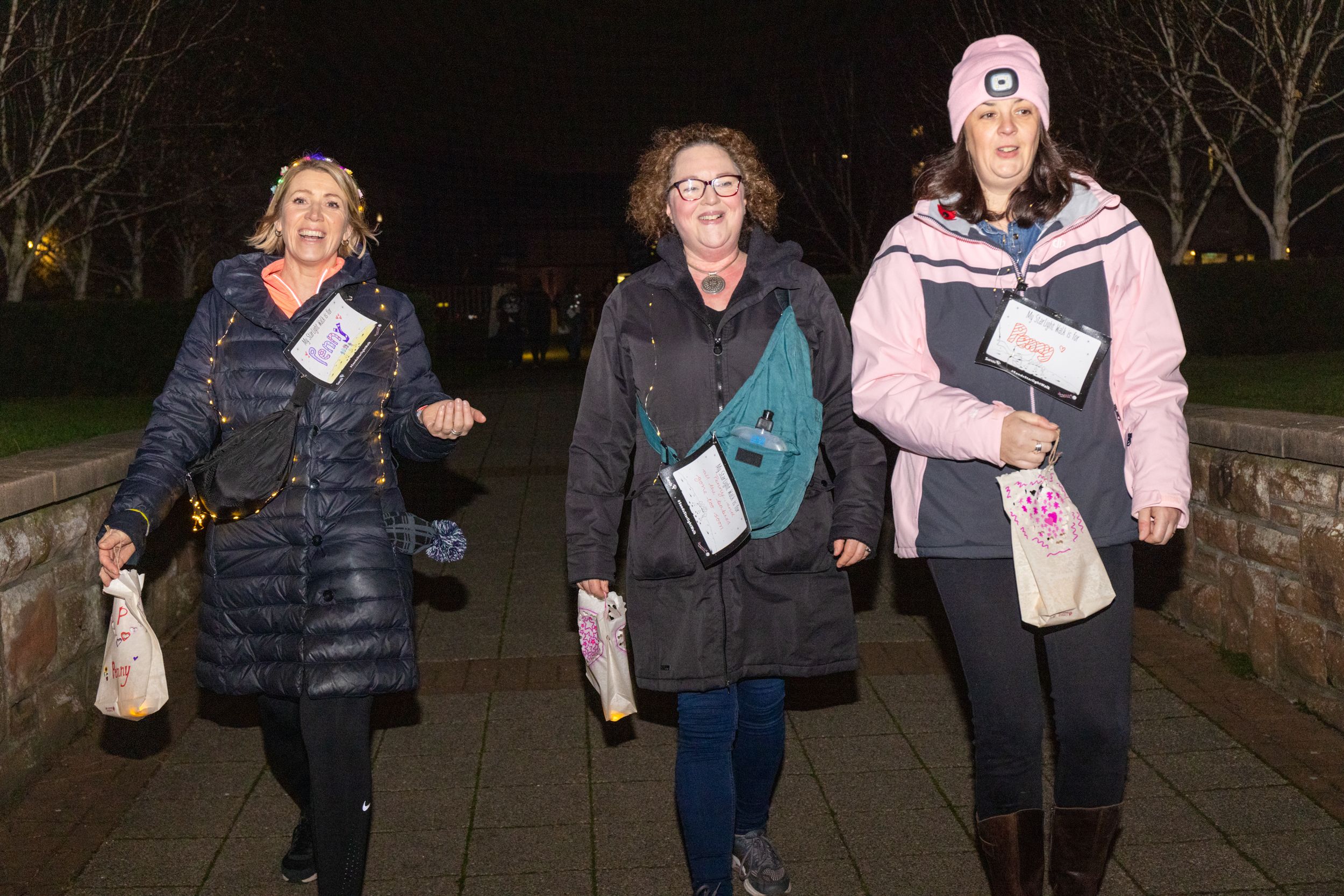 Three women walking along a path as part of a Sands Starlight Walk event in memory of their much-loved babies. 