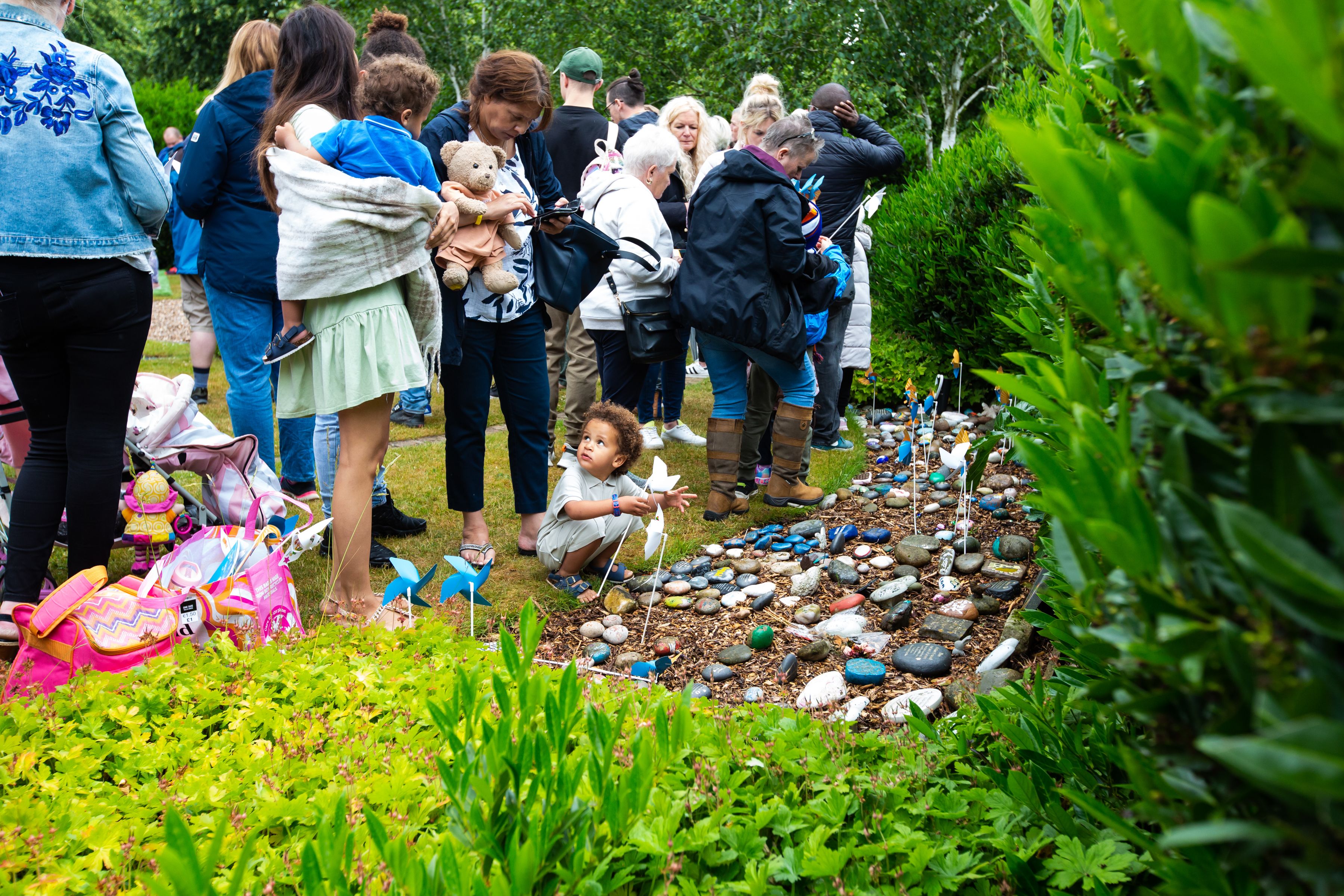 Families placing pinwheels during the Sands Garden Day Remembrance Event.
