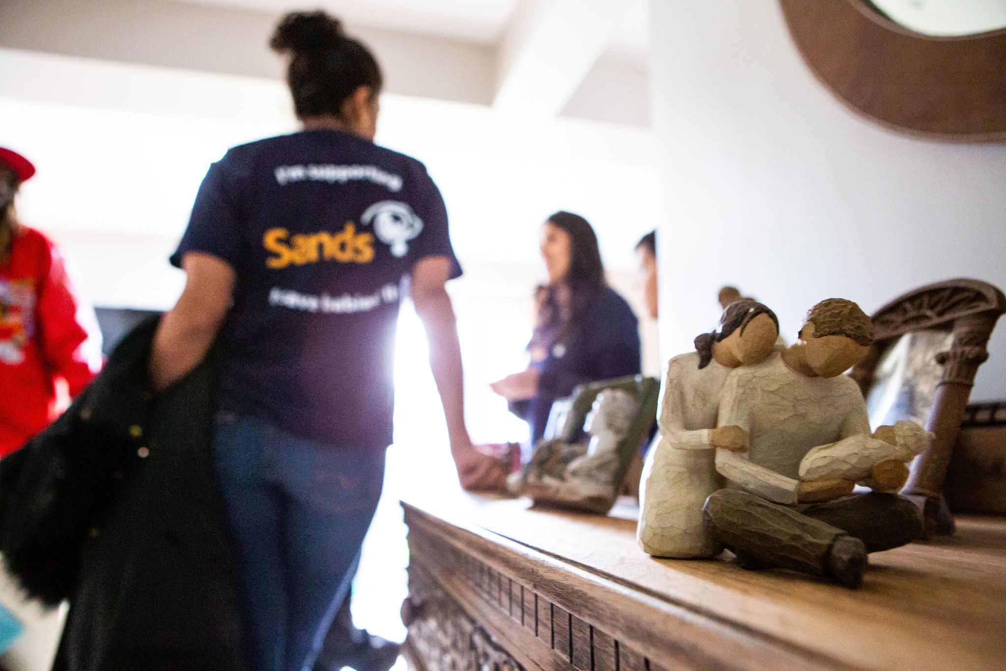 Two South Asian mothers talking in the background.