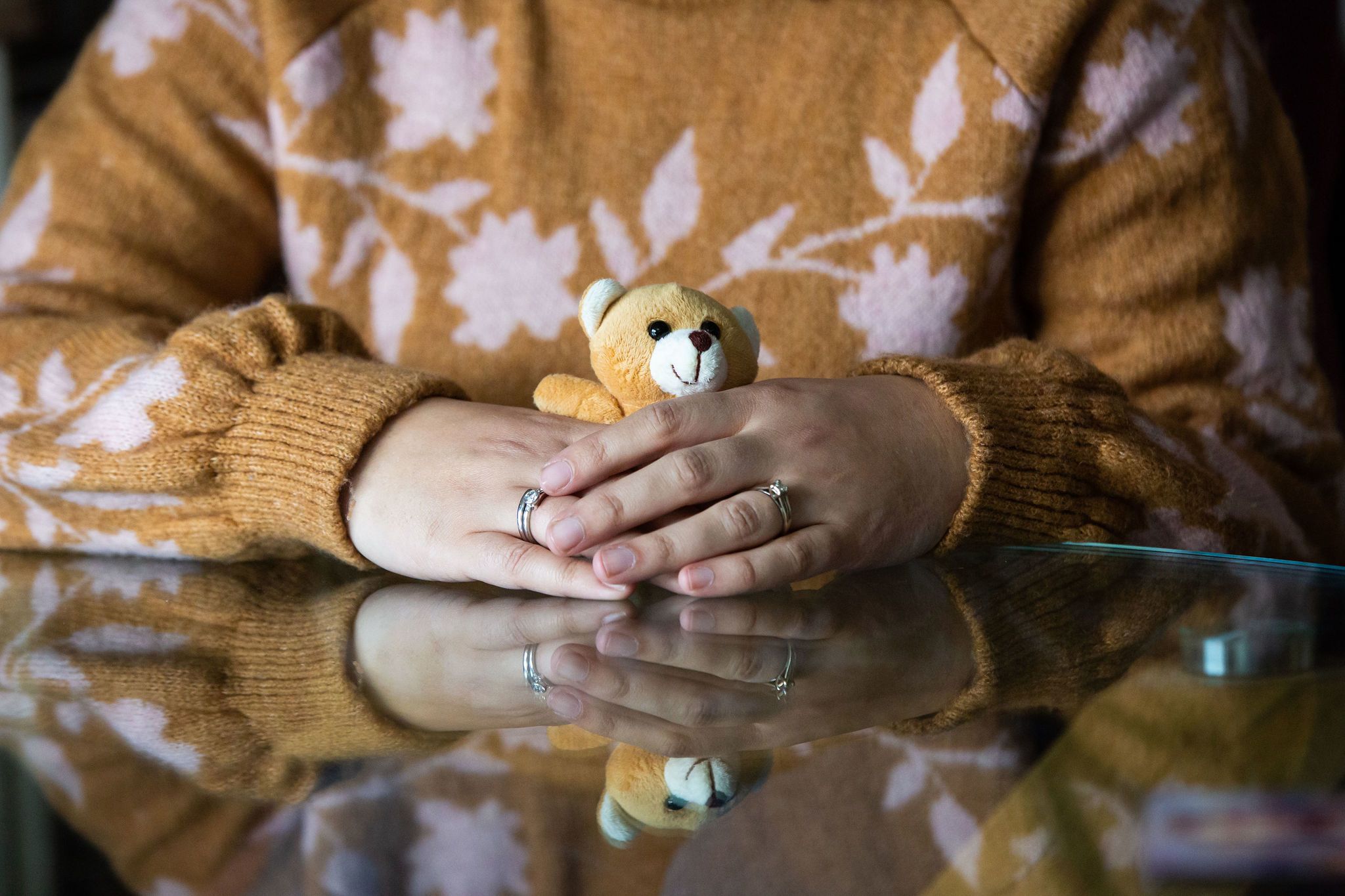 Bereaved mother holding a teddy bear from a memory box