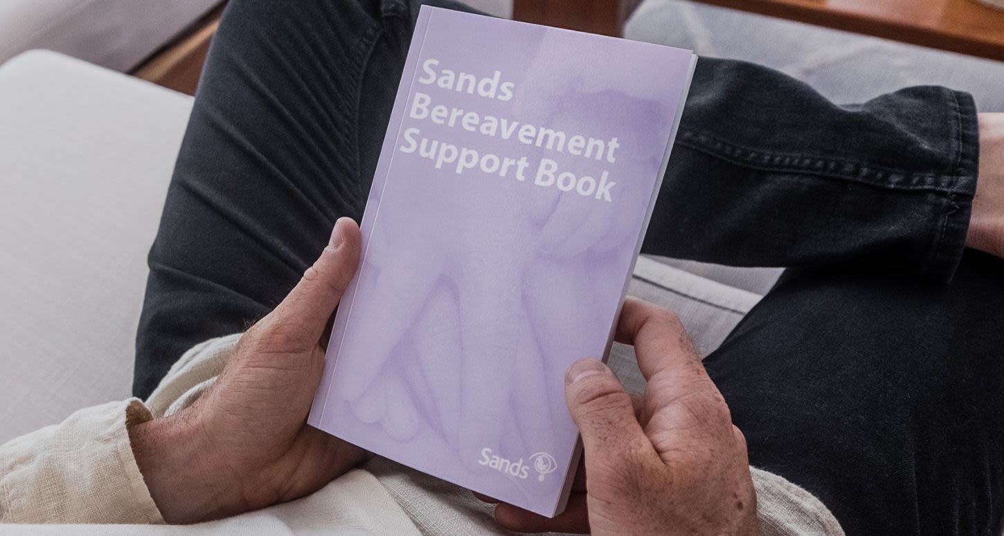 Parent holding a Bereavement Support Book