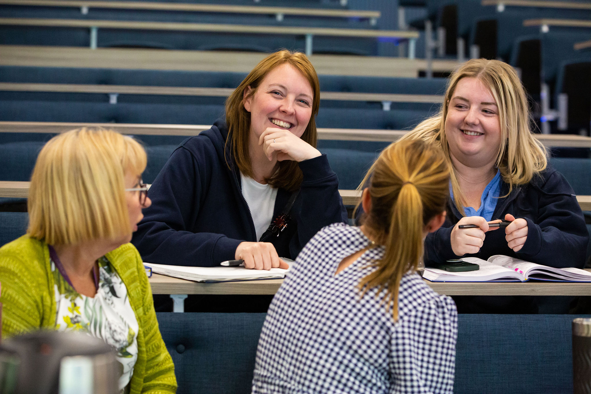Healthcare professionals smiling and talking during a Sands training session.
