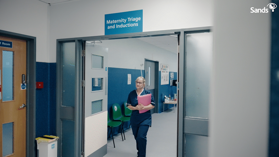 Healthcare professional walking through a Maternity Triage and Inductions hospital hallway.