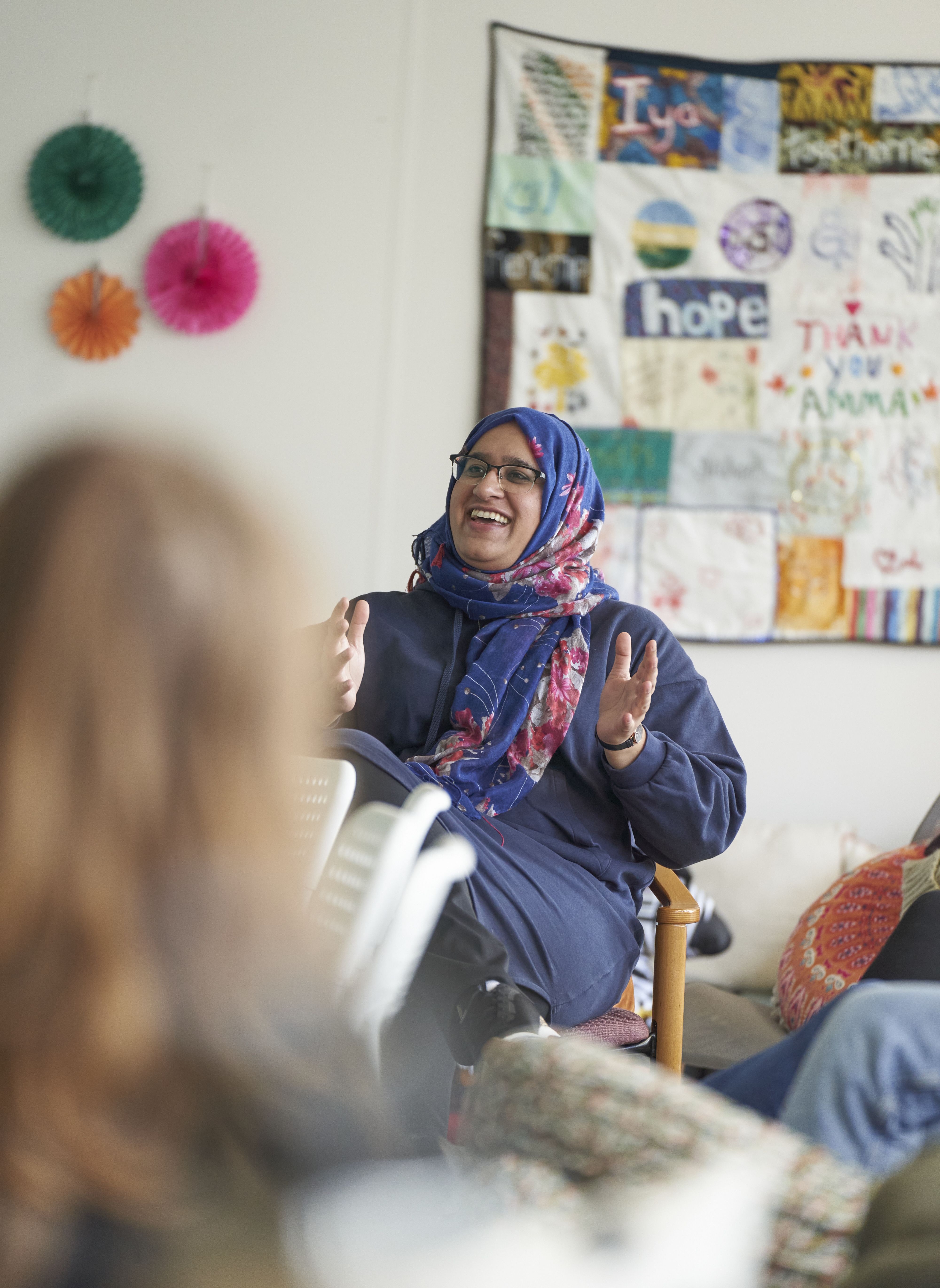 A healthcare professional presenting and speaking at a Sands training session. She is smiling and wearing a headscarf. 
