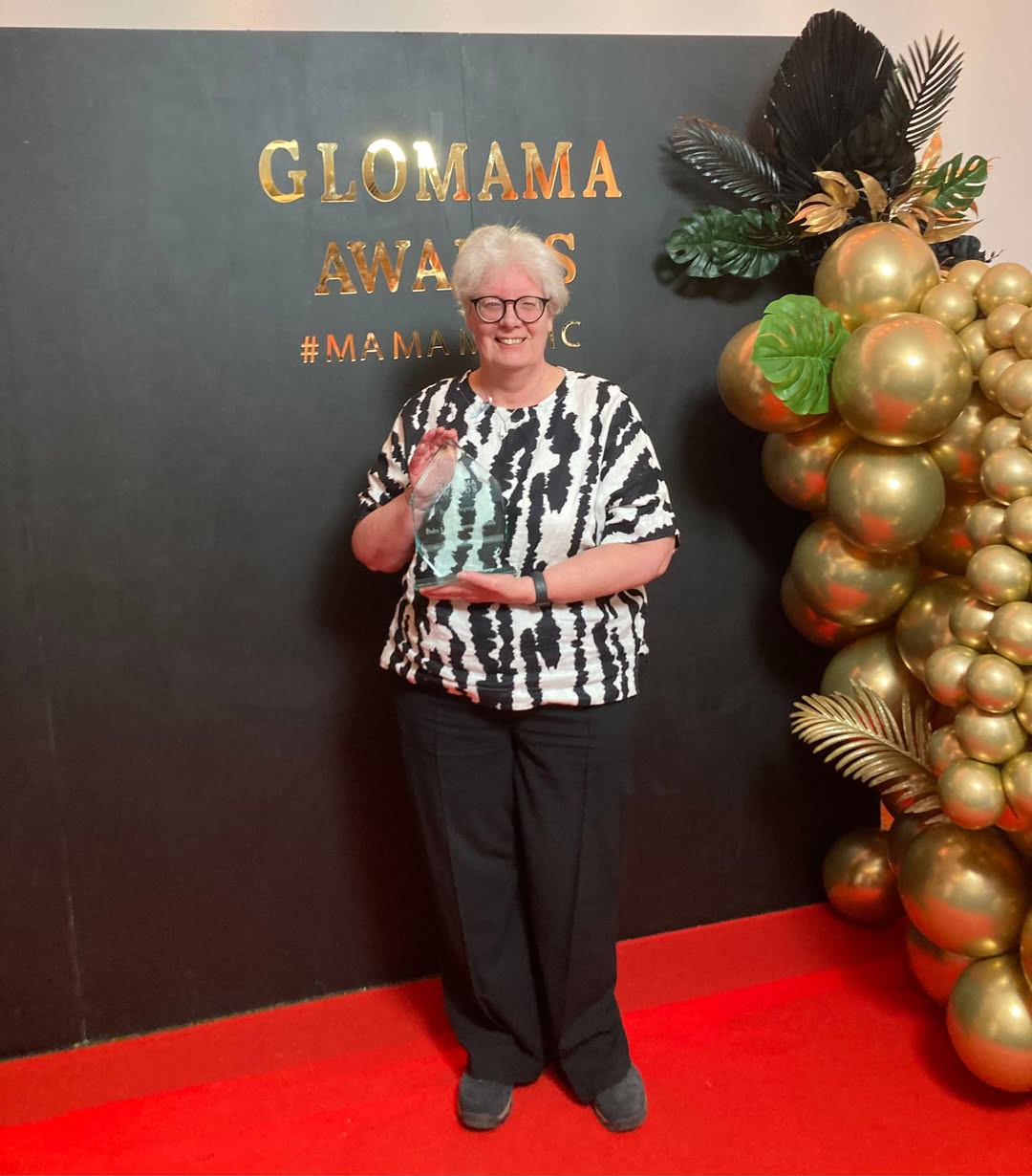 Marion Currie holding the GLOMAMA Award for Campaign of the Year.