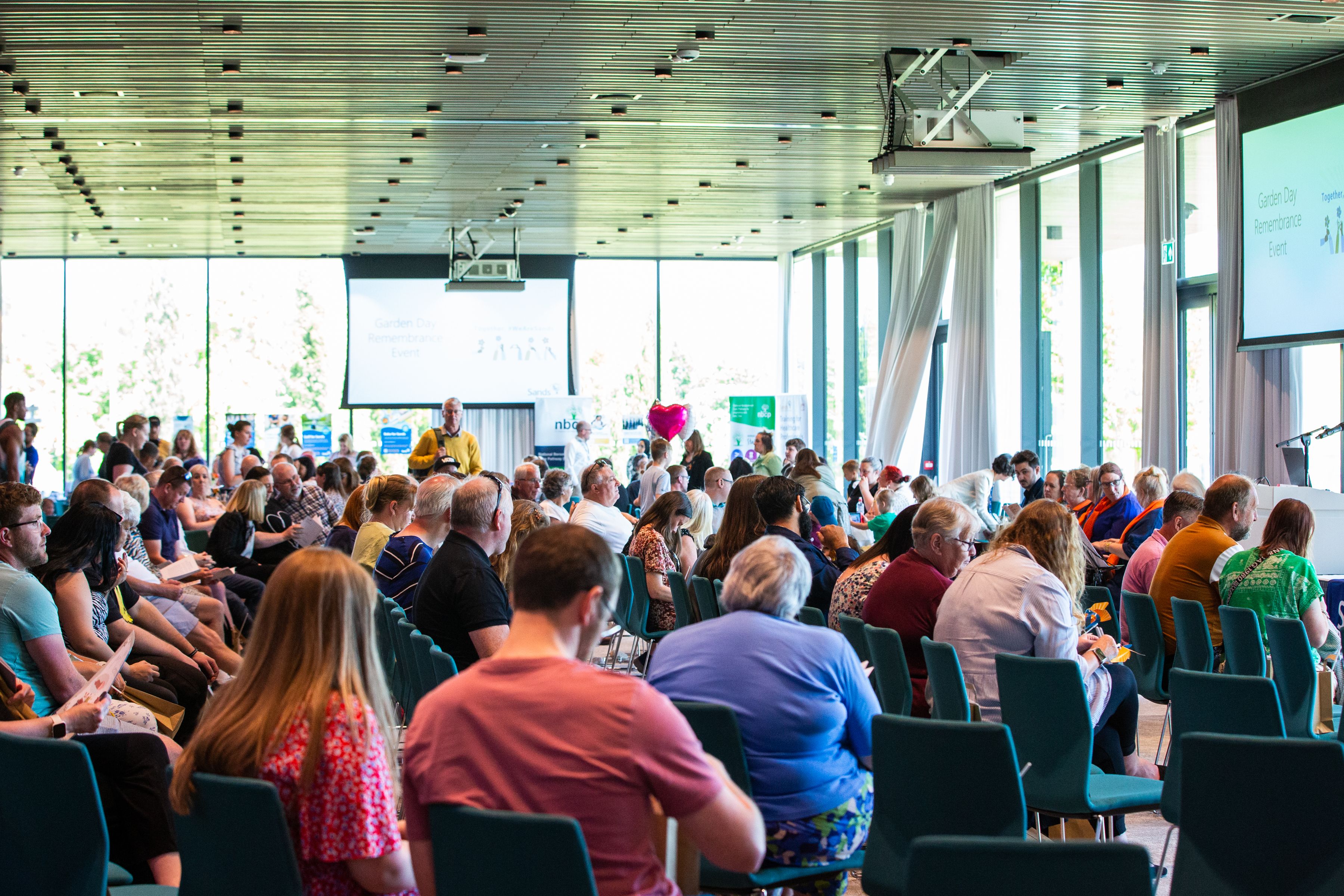 Bereaved Families sitting on chairs in rows inside at the Sands Garden Day 2023